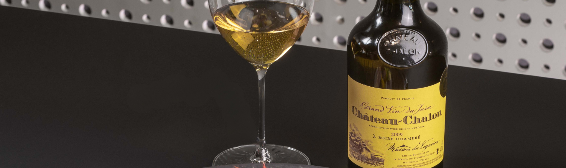 Clavelin de vin jaune du Jura et verre de vin à la robe dorée