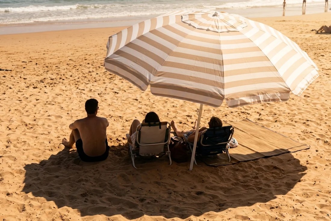 Parasol de plage anti-UV inclinable planté dans le sable avec son sac de transport