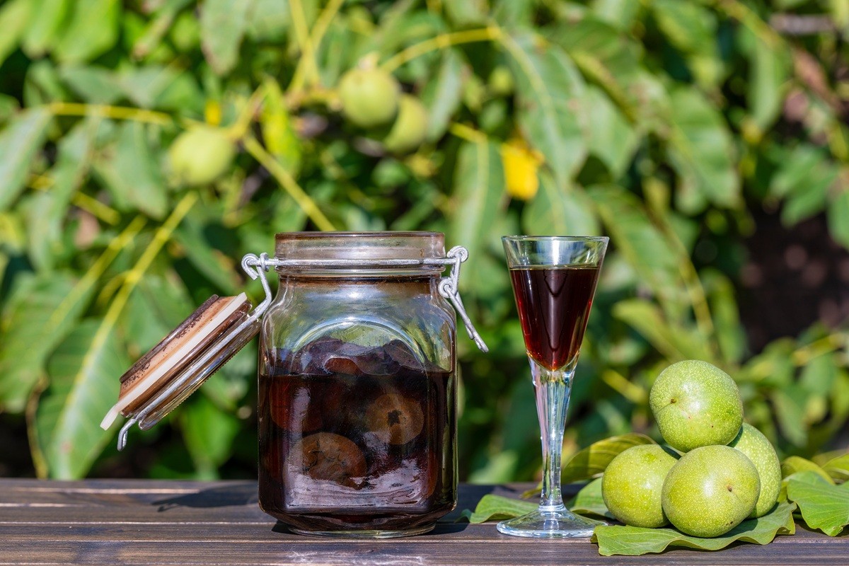 Bocal de vin de noix maison préparé avec des noix vertes