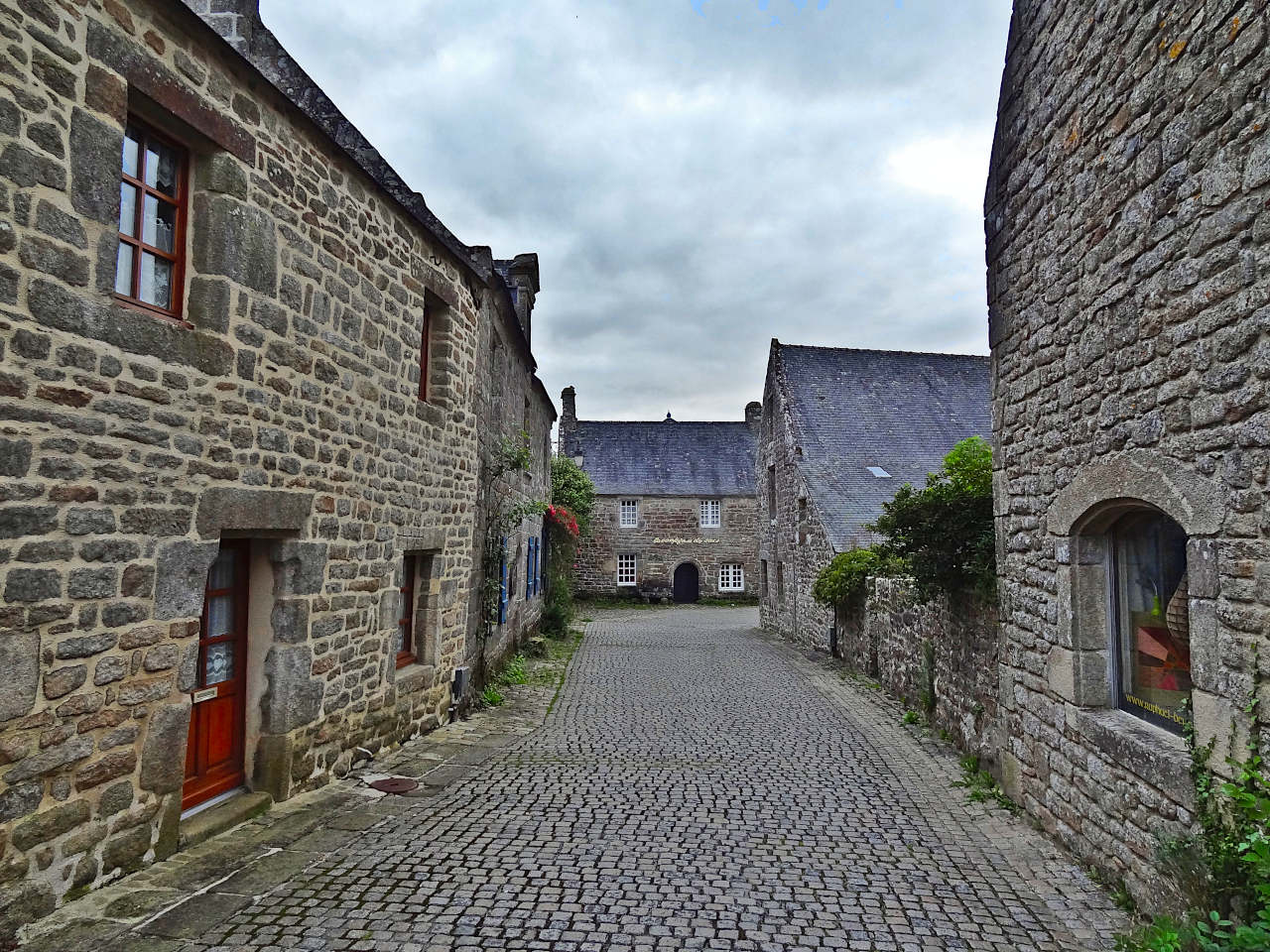 Place pavée de Locronan bordée de maisons en granit, avec l'église Saint-Ronan en arrière-plan
